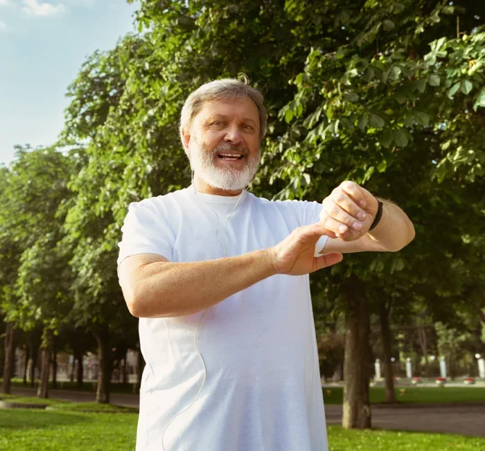 Active older man checking his pulse during a walk in the park